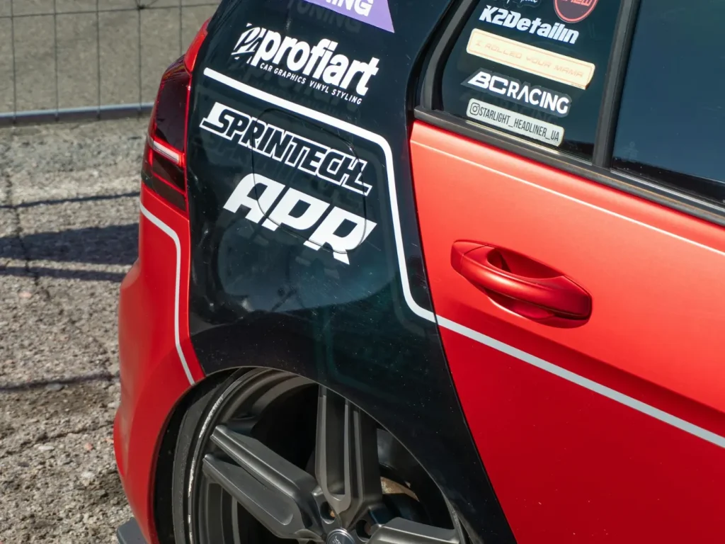 Carro vermelho com autocolantes desportivos e jantes personalizadas, autocolantes para viaturas