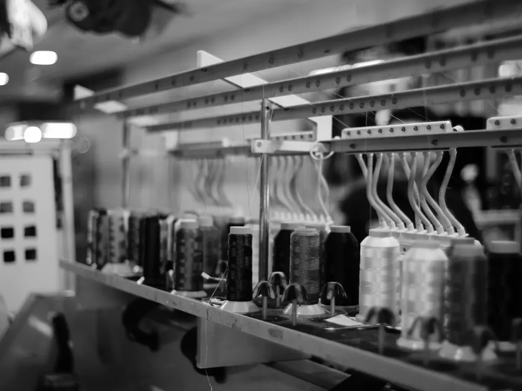 Máquina de bordar industrial com várias bobinas de linha, bordados em bonés e chapéus em Bragança