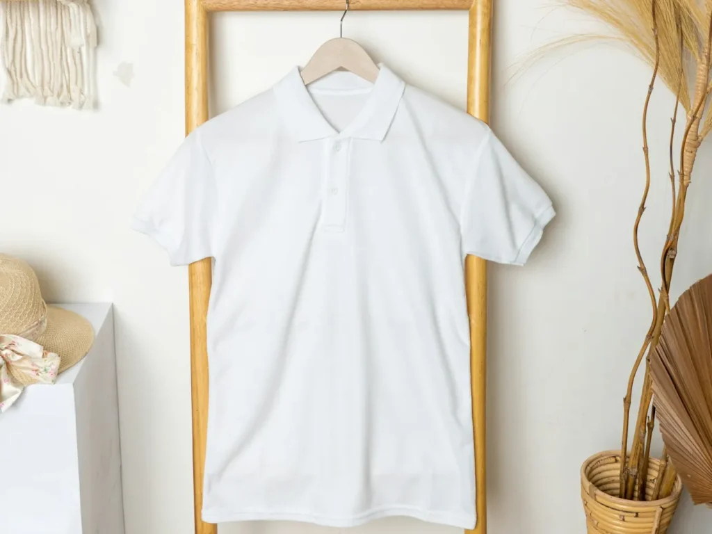 Polo branco pendurado num cabide, bordados personalizados em polos, casacos e sweats