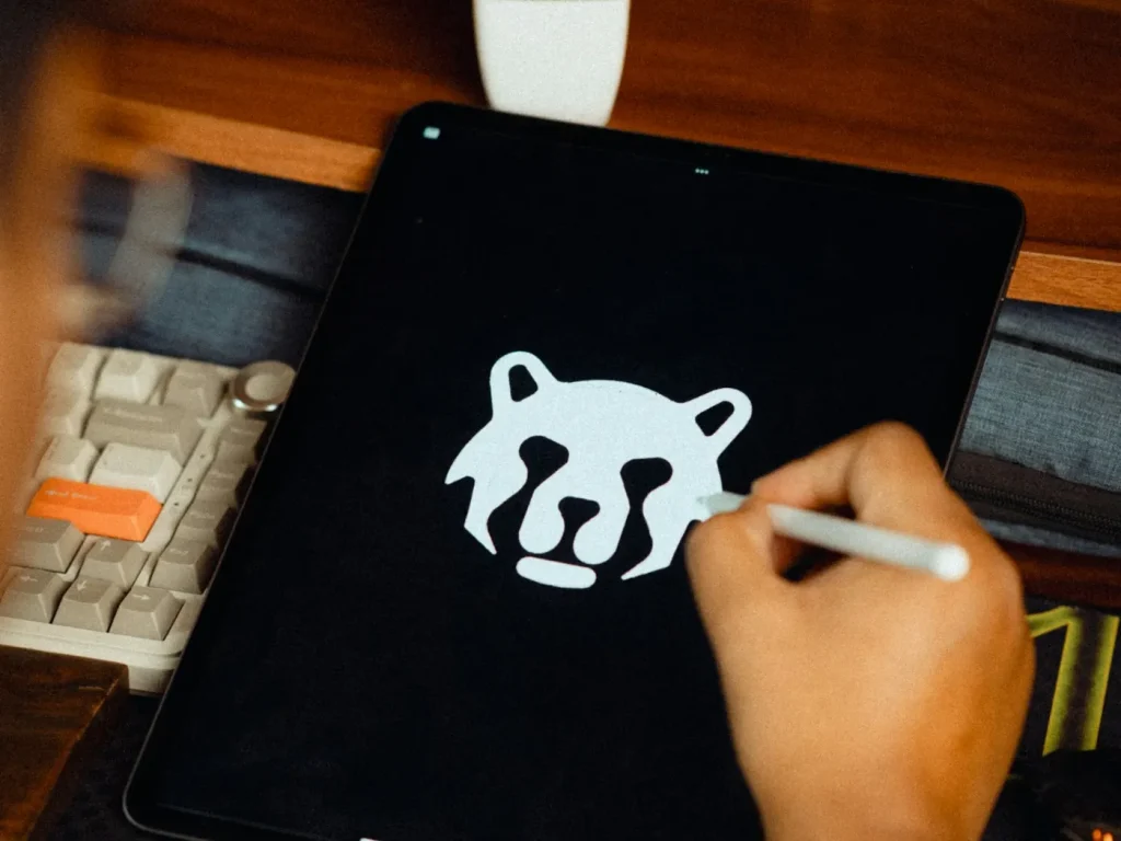 Designer a desenhar um logótipo num tablet com caneta digital, criação de logótipos em Bragança