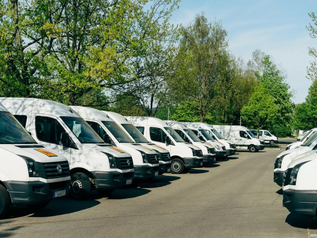 Fila de carrinhas comerciais brancas estacionadas, prontas para decoração de frotas empresariais