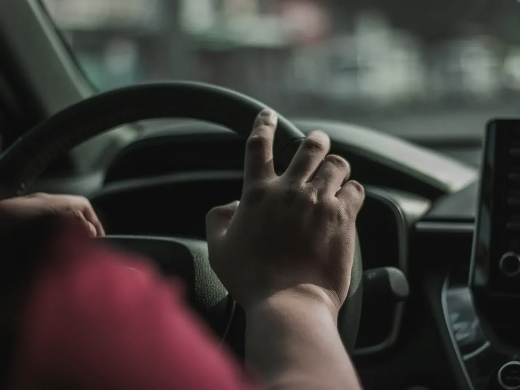 Condutor com a mão no volante durante uma aula de condução, escolas de condução em Bragança