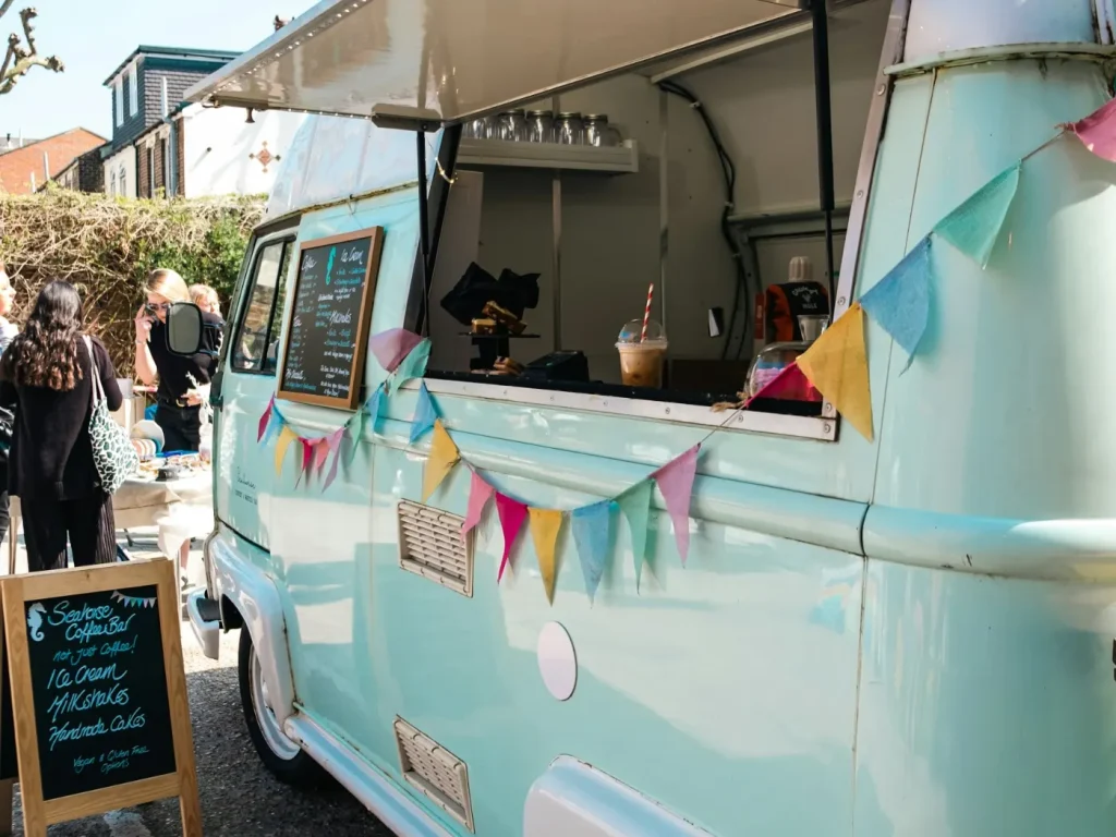 Food truck azul e branco estacionado ao ar livre, decoração de food trucks e roulottes