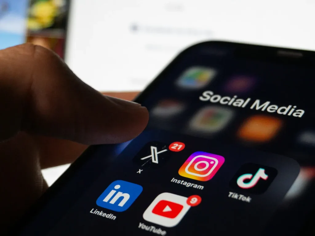 Mão a segurar smartphone com feed de redes sociais aberto, gestão de redes sociais em Bragança