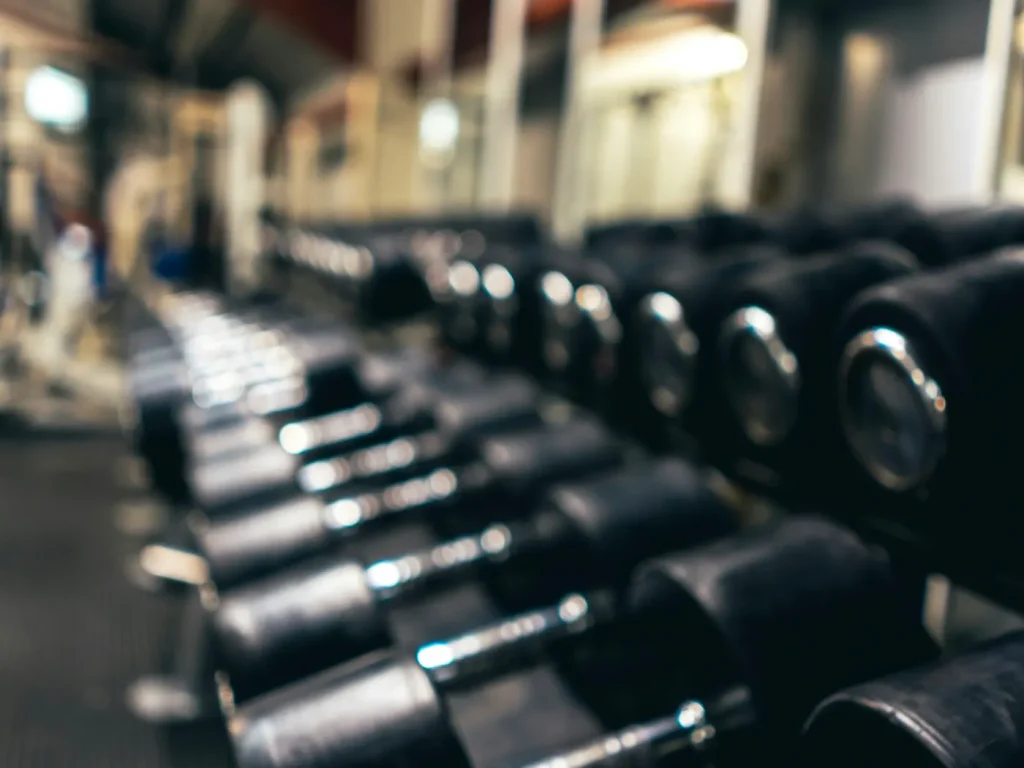 Fila de halteres pretos num suporte de ginásio, marketing para ginásios e health clubs em Bragança