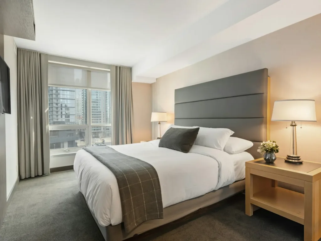 Quarto de hotel com cama feita e roupa branca, promoção de hotéis e alojamento em Bragança