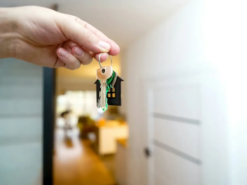 Mão segura as chaves de casa à entrada da habitação, imobiliárias e mediação imobiliária em Bragança