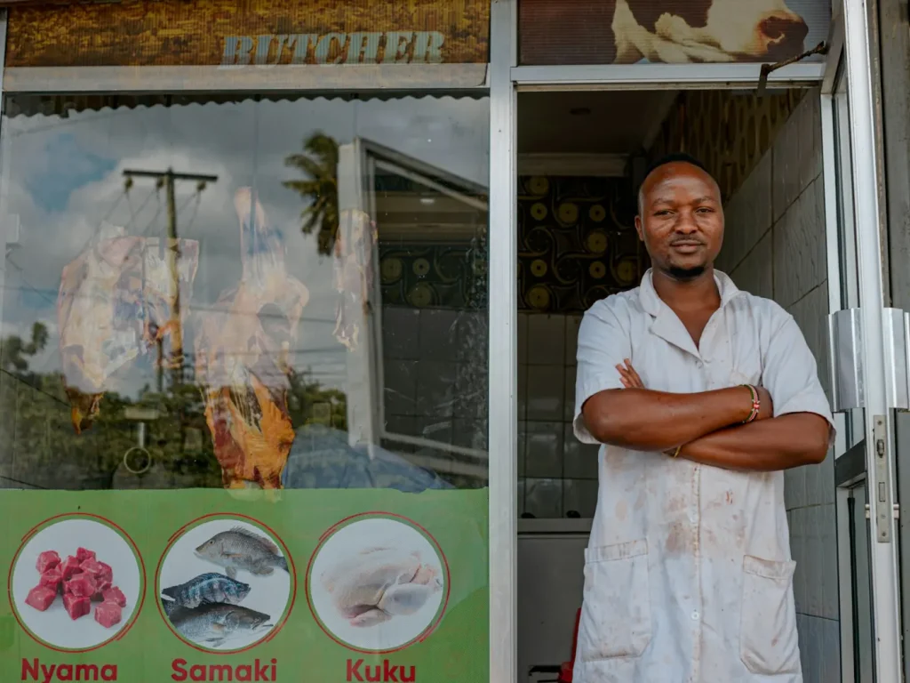 Comerciante de braços cruzados à porta da sua loja, comércio local em Trás-os-Montes