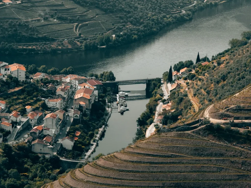Vista aérea de uma vila junto a um rio, marketing digital para empresas de Alijó