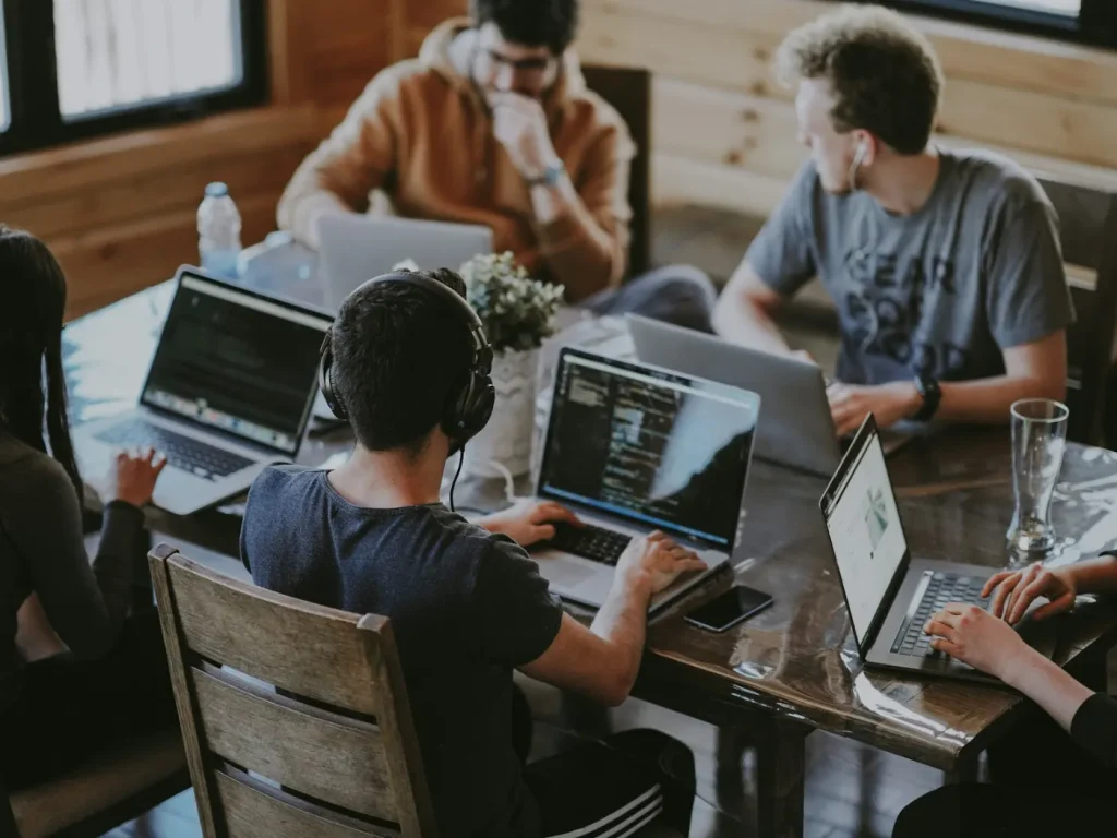 Equipa reunida à volta de portáteis a planear campanhas, marketing digital em Bragança