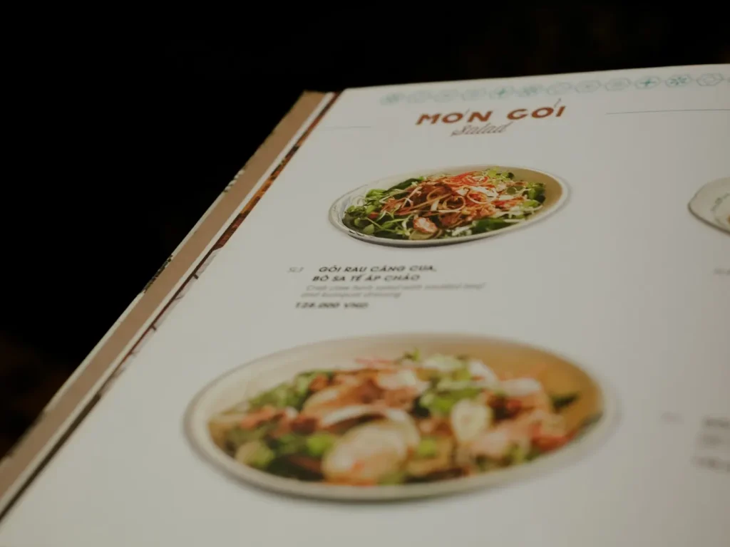 Menu impresso aberto sobre mesa de madeira num restaurante, impressão de menus para restaurantes