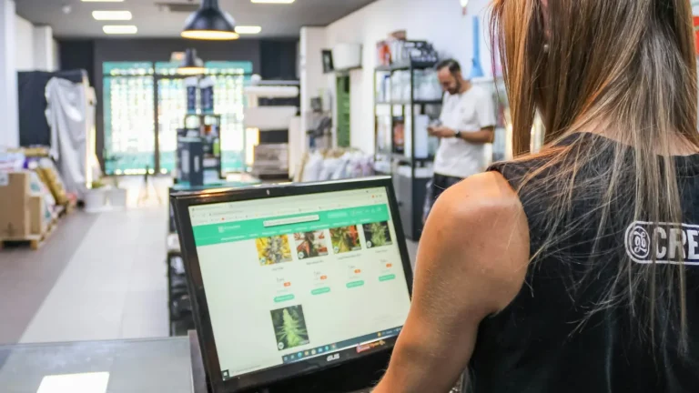 Mulher a trabalhar no computador dentro de uma loja, a atualizar o site da empresa