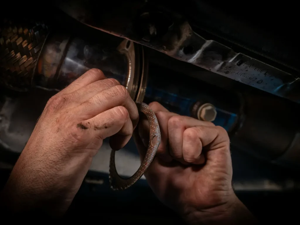 Mecânico a reparar o motor de um carro com chave inglesa, oficinas e stands automóveis em Bragança