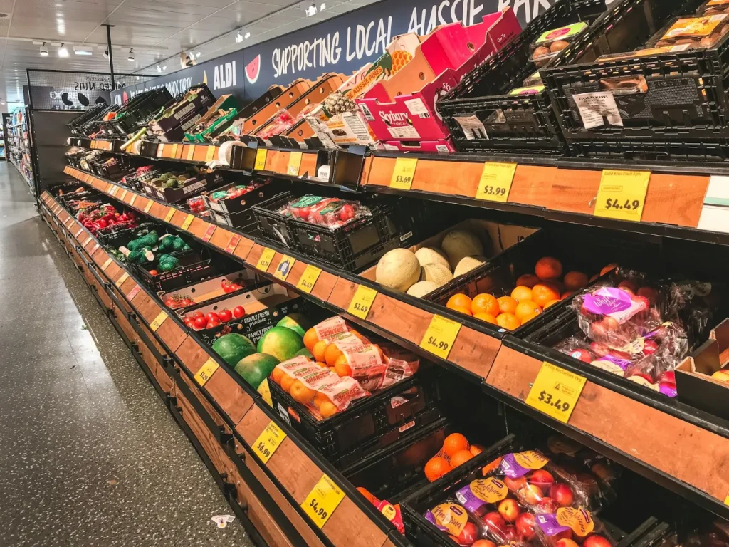 Frutas variadas expostas em prateleiras de madeira, supermercados e mercearias de proximidade em Bragança