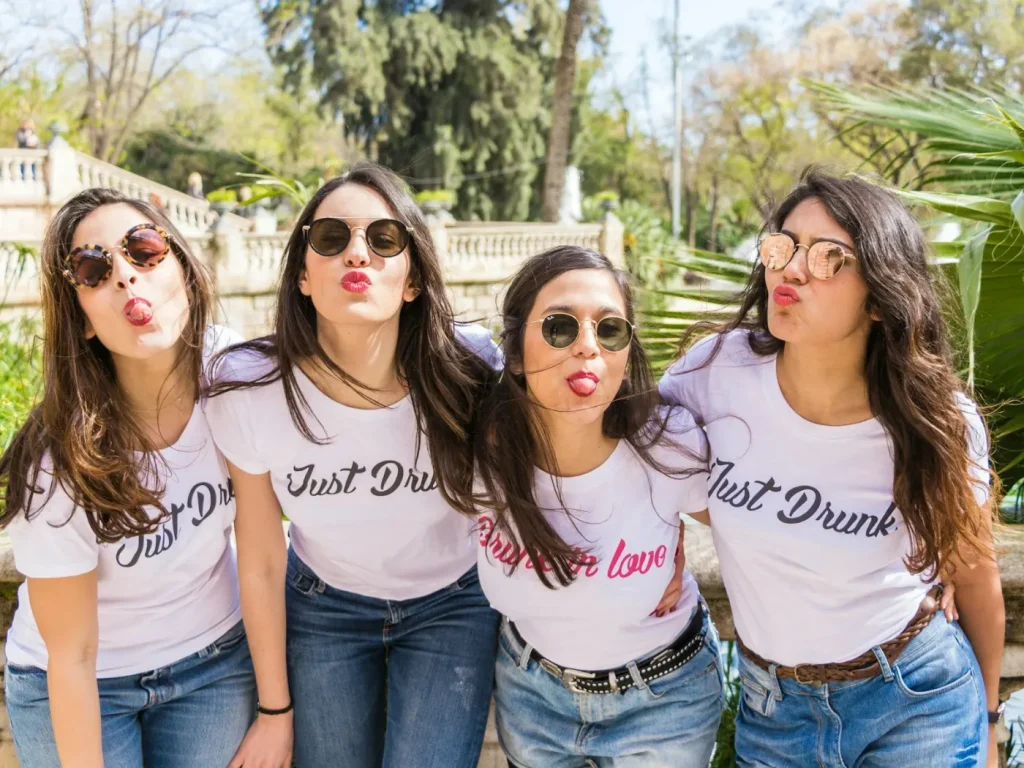 Quatro amigas com t-shirts cor-de-rosa iguais, t-shirts personalizadas para eventos e despedidas