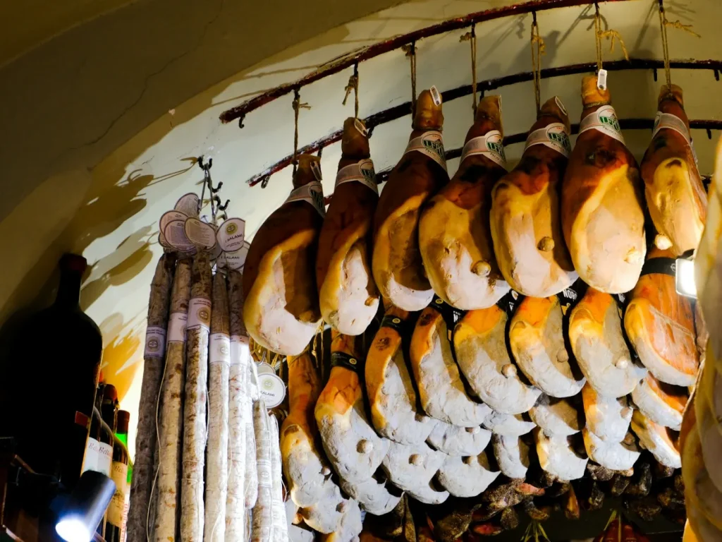 Enchidos e presuntos pendurados a curar numa cave abobadada, talhos e fumeiro de Trás-os-Montes