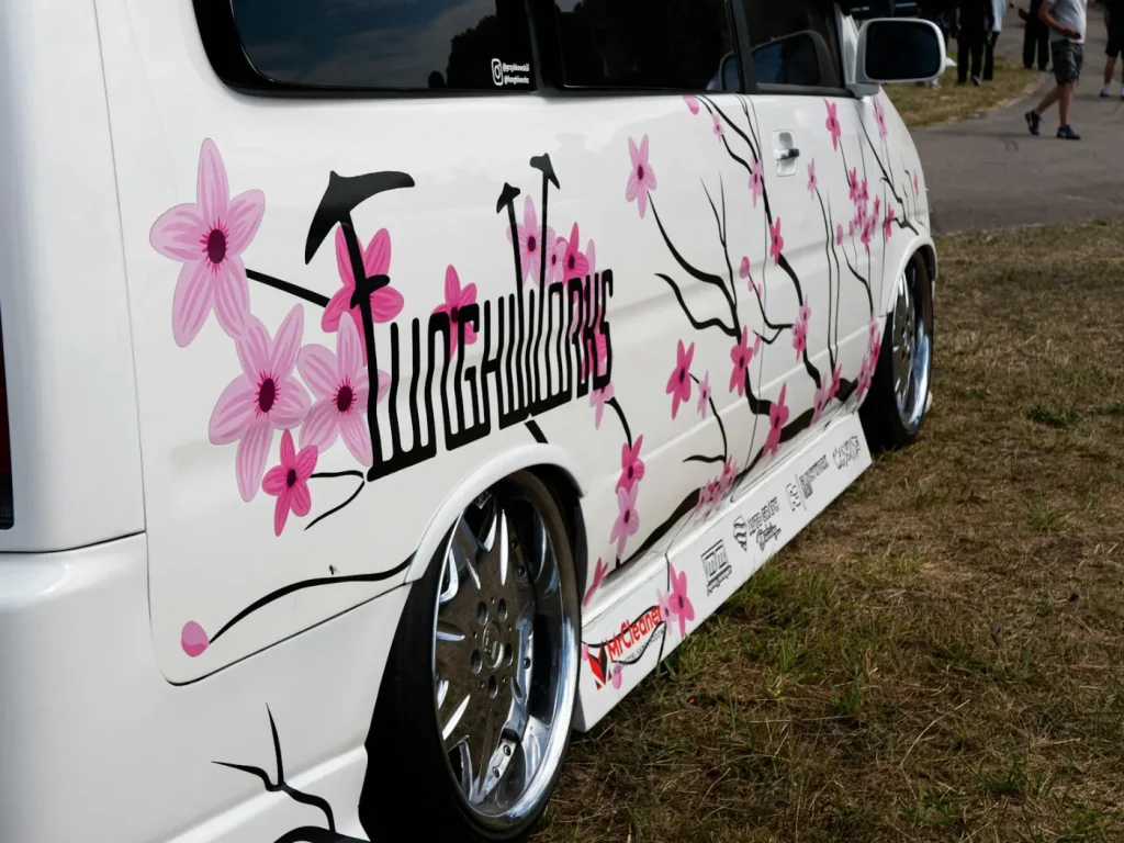 Carrinha branca personalizada com ilustração de flores de cerejeira, viaturas personalizadas em Bragança